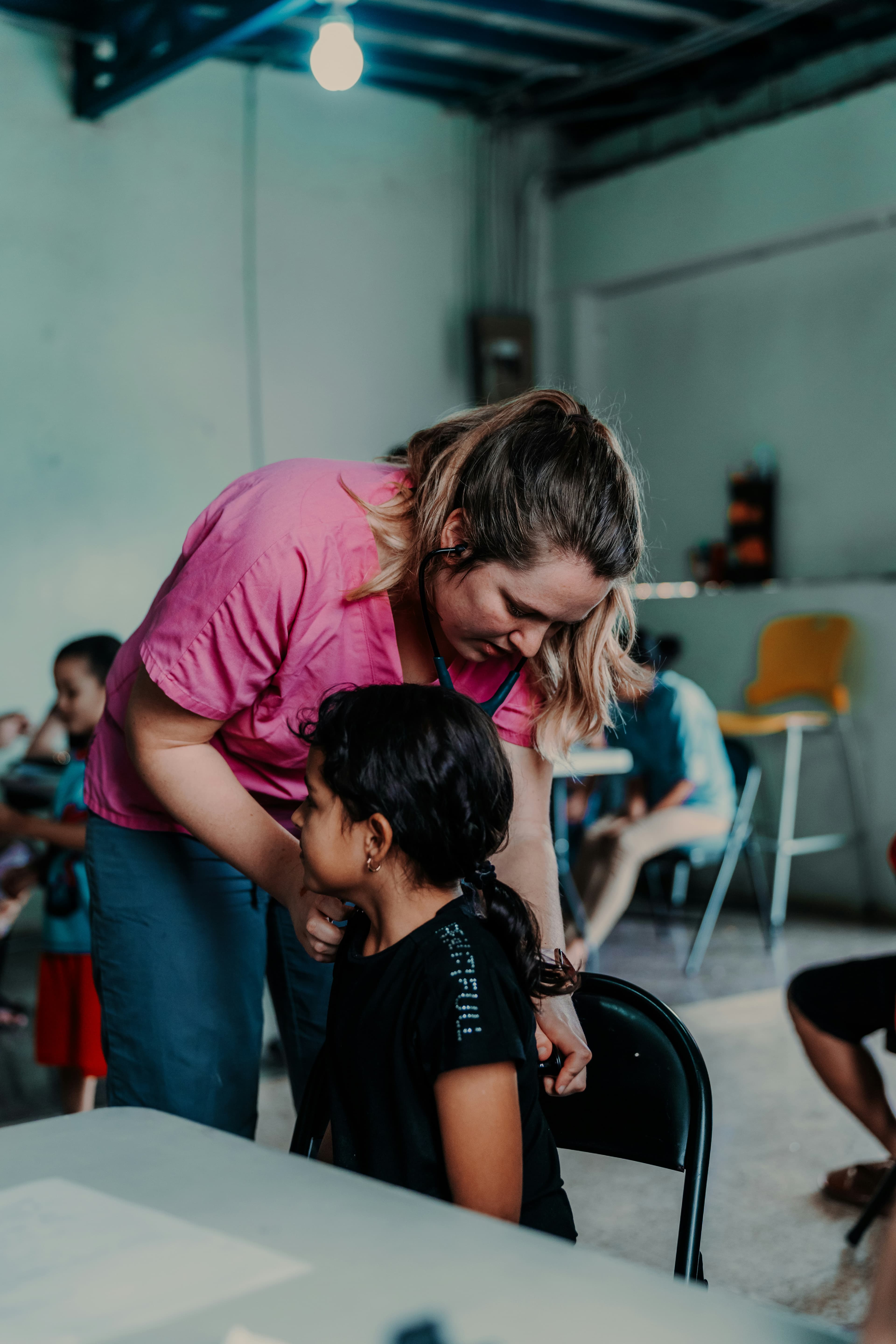 A volunteer nurse cares for a patient at a field clinic