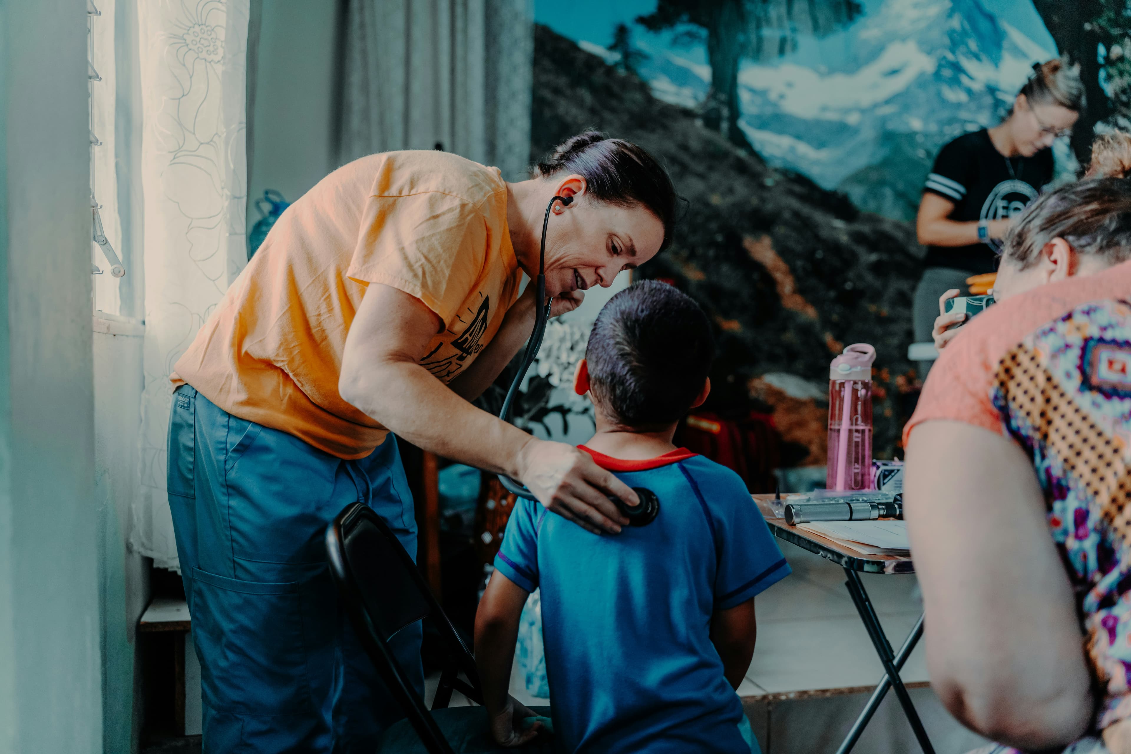 A volunteer cares for a young patient at a field clinic