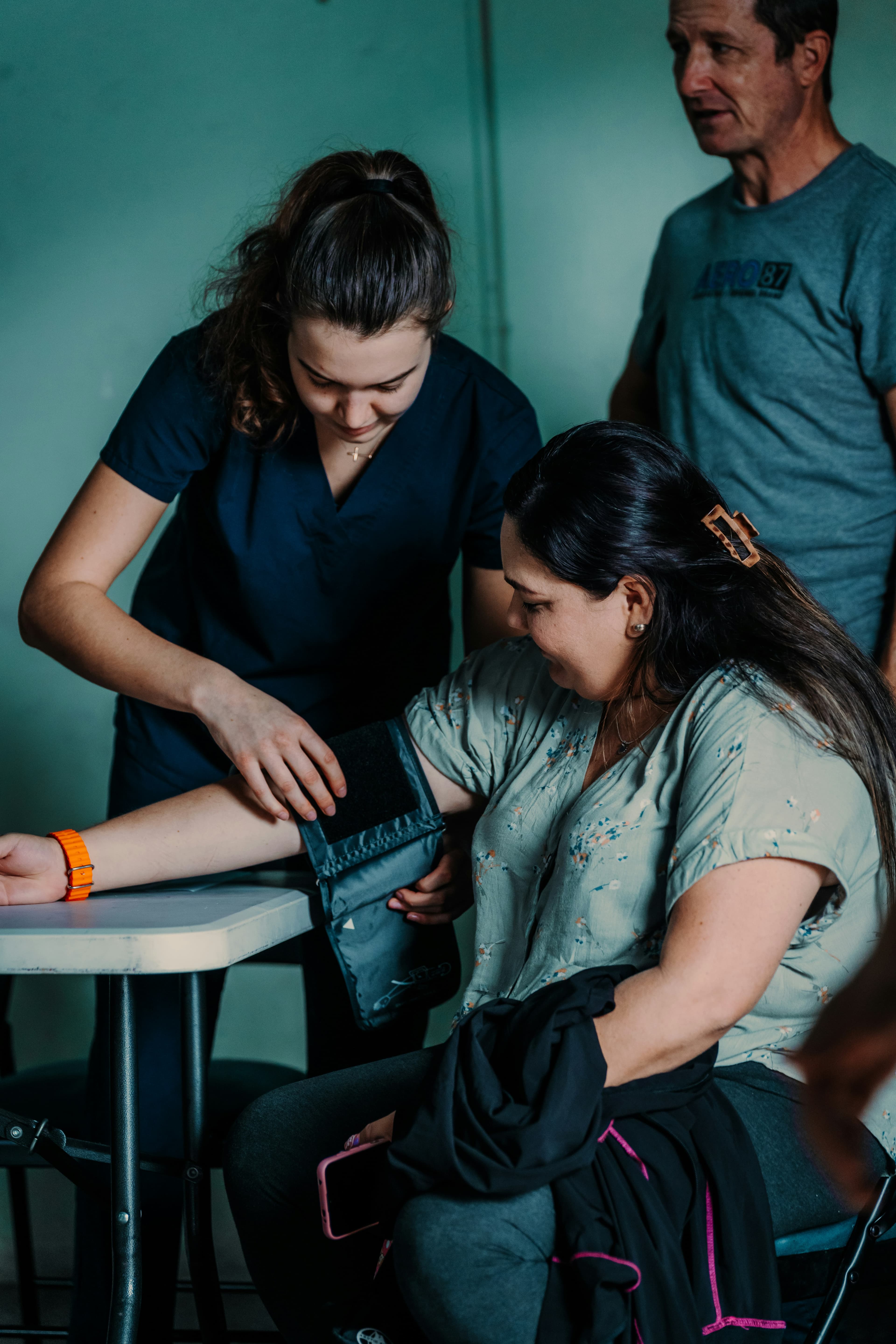 A volunteer takes a blood-pressure reading at a clinic