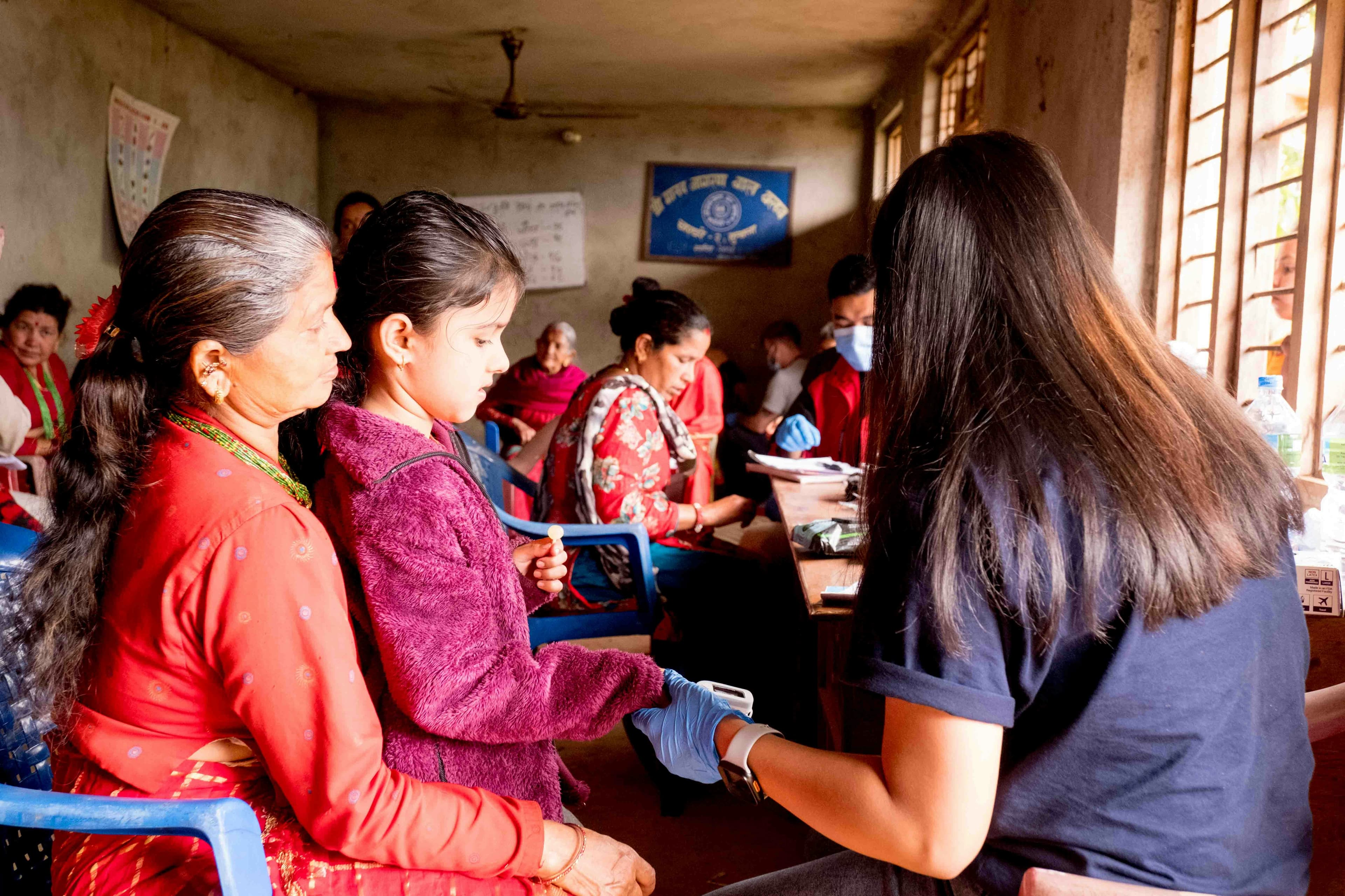 A medical volunteer meets with families at a village clinic