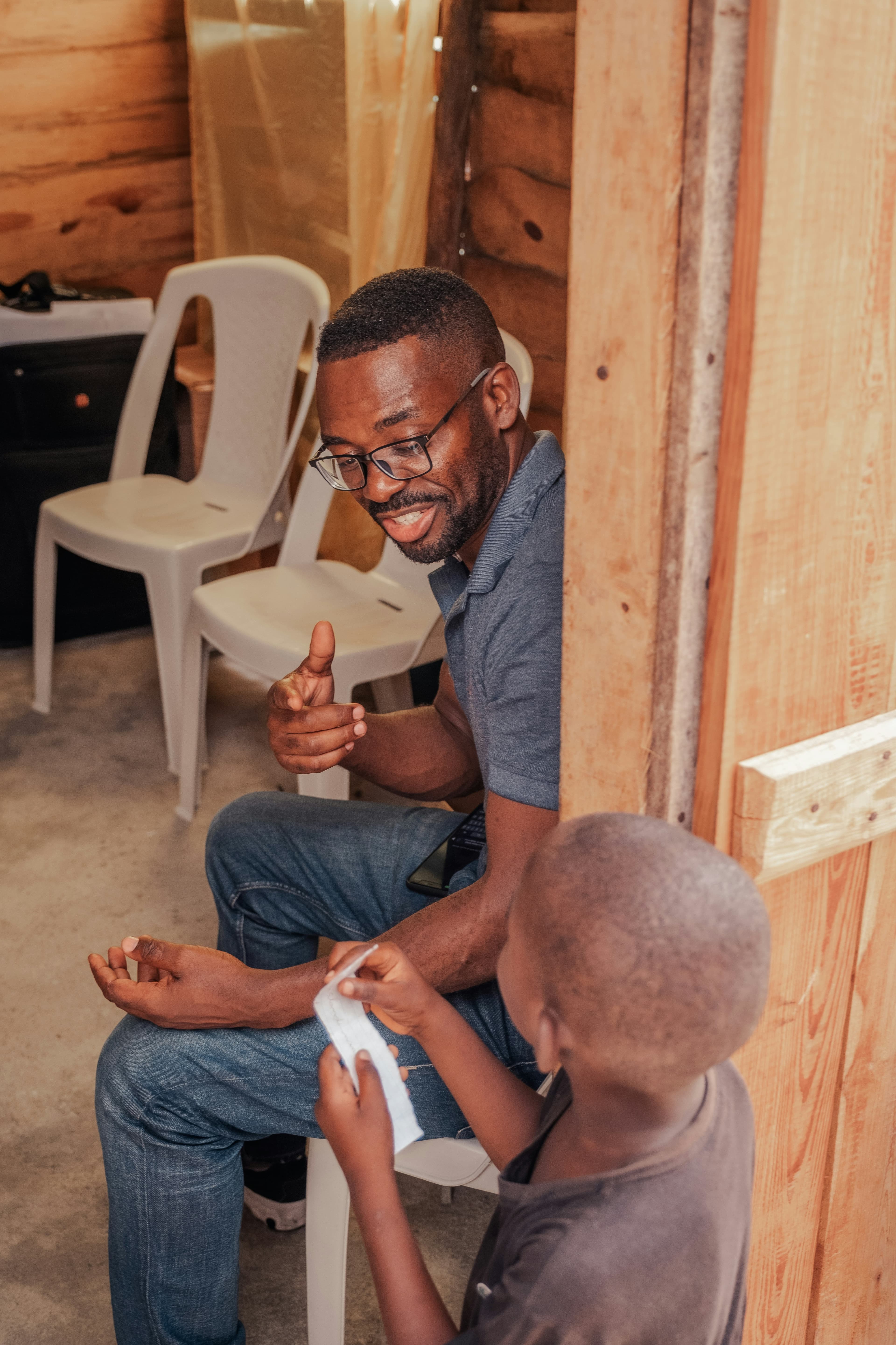 A volunteer talks with a young patient during a home visit